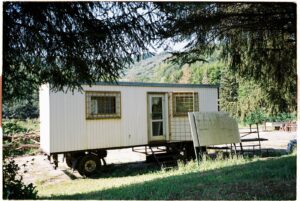maison en bois blanche près des arbres verts pendant la journée