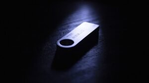 Clé USB brillante sur fond noir, lumière concentrée