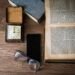 livre ouvert, montre, smartphone, lunettes et boîte sur table en bois