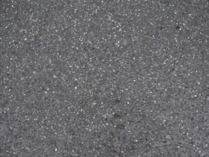 Surface granuleuse avec taches sombres et éclats de lumière