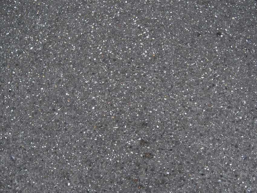 Surface granuleuse avec taches sombres et éclats de lumière Surface granuleuse avec taches sombres et éclats de lumière