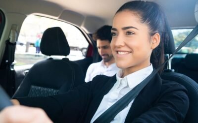 Une femme souriante conduit, passager assis, ceintures, intérieur automobile