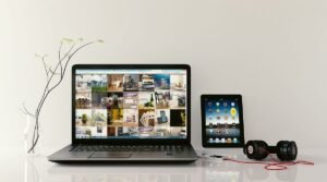 Laptop et tablette sur une table avec écouteurs et écran coloré