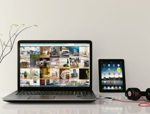 Laptop et tablette sur une table avec écouteurs et écran coloré