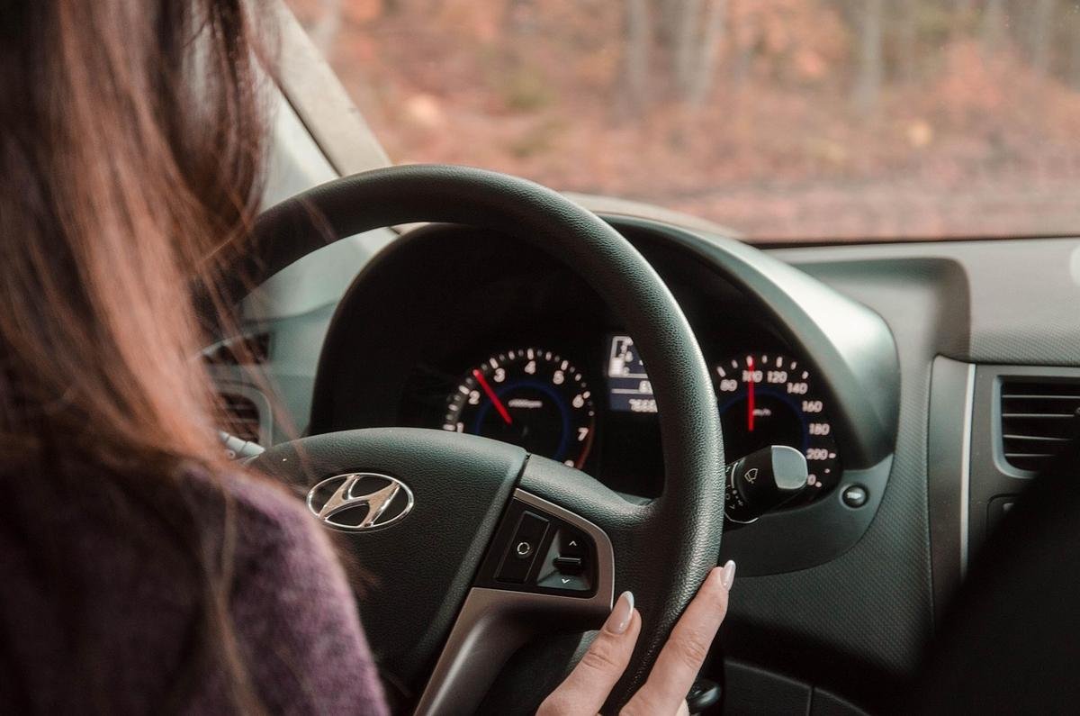 Une femme conduit une Hyundai main sur le volant tableau de bord visible