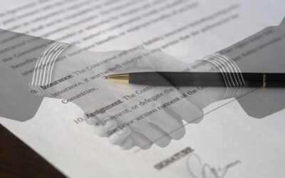 Mains serrées sur un papier avec une plume posée dessus, signature en bas