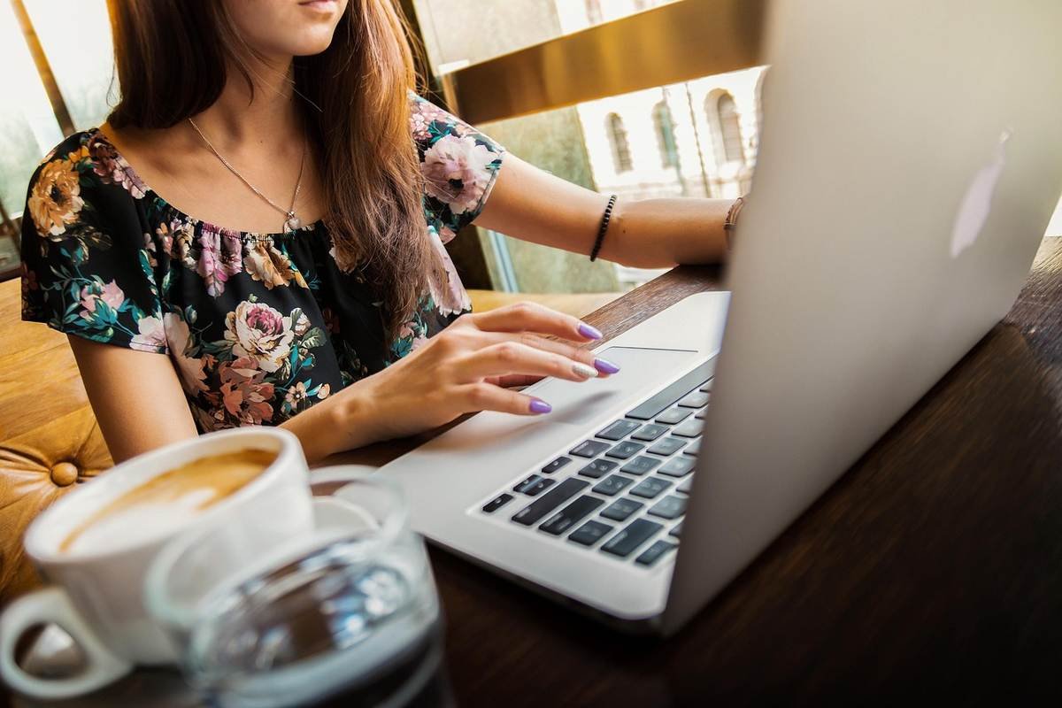 Femme travaillant sur un ordinateur portable dans un café